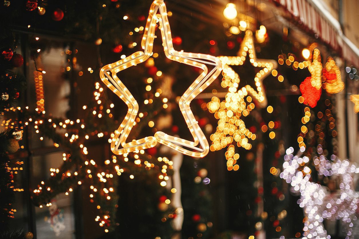 Stars made of Christmas lights hang outside the window of a print marketing business